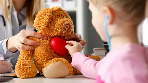 Kleines Mädchen untersucht Teddybären mit Stethoskope